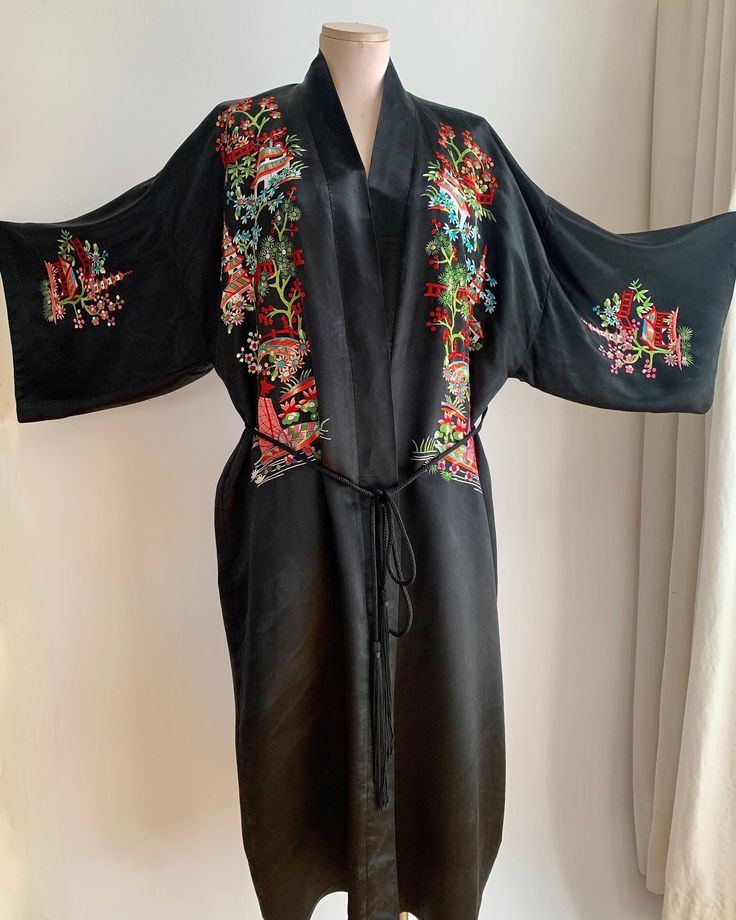 Vintage Chinese Silk Kimono in black with colorful embroidery details on the front, back as well as the sleeves. The inside is totally lined with a sheer black silk. This comes with a woven black sash with fringe. This piece is quite striking. This would make a great dressing gown, lingerie or cape-like jacket for a special night out.. This also could be hung on a wall with a bamboo rod as a beautiful art piece. This is in EXCELLENT VINTAGE CONDITION.. with one flaw to mention.. There is a snag Long Kimono With Multicolor Floral Embroidery, Black Kimono For Festival, Embroidered Multicolor Kimono For Festivals, Long Multicolor Floral Embroidered Kimono, Fitted Long Sleeve Kimono With Floral Embroidery, Black Fitted Long Kimono, Fitted Long Black Kimono, Black Kimono With Floral Embroidery, Spring Silk Kimono With Embroidery