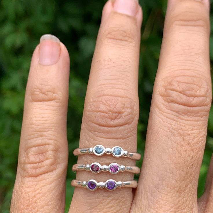 Wear them on their own or stacked all the way up your finger, our gemstone stacking bands in reclaimed sterling silver are the perfect addition to your daily jewels, a perfect gift for a loved one or yourself. Available in Ruby, Rhodolite Garnet, London Blue Topaz, Peridot, Amethyst, Blue Zircon, Spessartite Garnet, and Moonstone and mixed (pick your own stones) Each Stone measures approx 2.5mm. These beautiful pieces are handmade to order in Emily's Hudson Valley studio. Please allow 14-21 busi Dainty Multi-stone Sterling Silver Jewelry, Dainty Stackable Amethyst Ring For Anniversary, Sterling Silver Birthstone Jewelry With Round Band, Adjustable Multi-stone Stackable Rings, Everyday Adjustable Stackable Birthstone Ring, Sterling Silver Round Band Gemstone Jewelry, Sterling Silver Gemstone Jewelry With Round Band, Sterling Silver Jewelry With Gemstone In Round Band, Stackable Sterling Silver Birthstone Ring Fine Jewelry