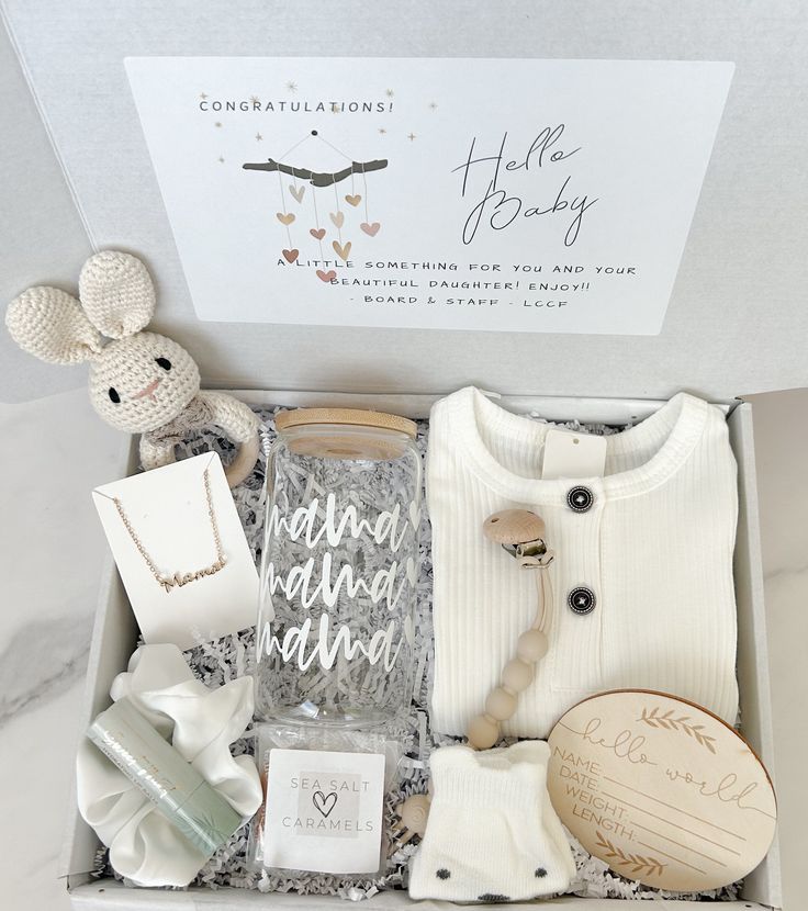 an open box containing items from the baby's first christmas gift set, including a teddy bear and sweater