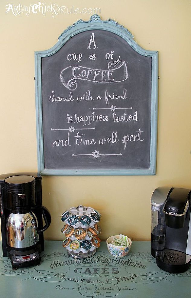 there is a chalkboard sign on the wall next to some coffee pots and cups