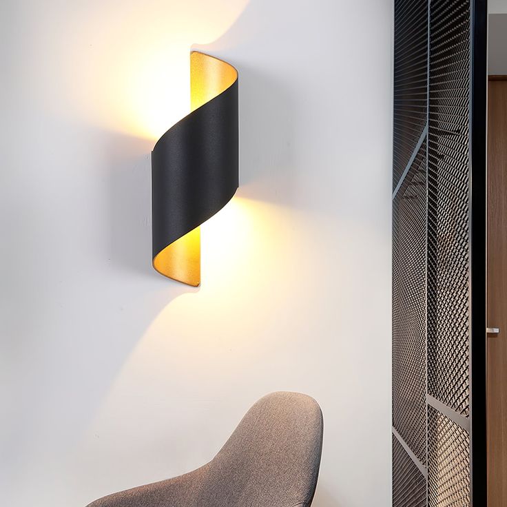 a modern light fixture mounted on the wall next to a chair and closet door in an office