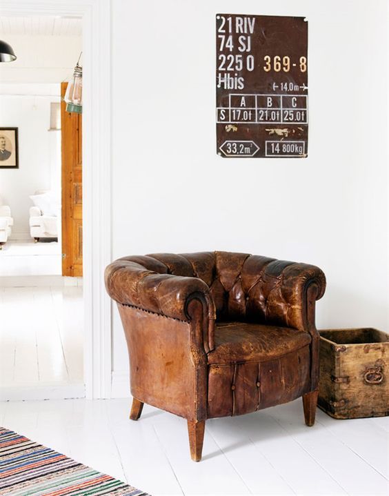 a leather chair sitting in front of a white wall