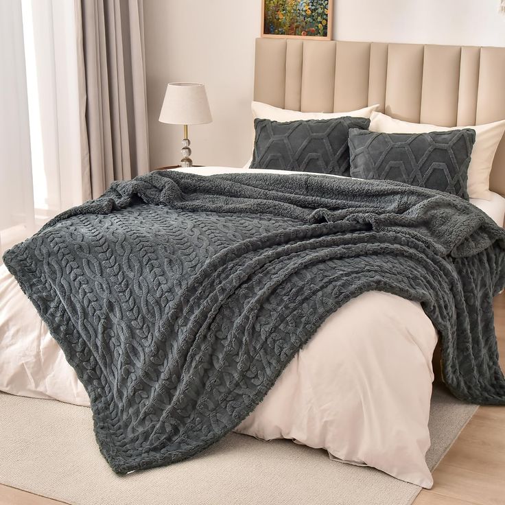 a bed with a blanket and pillows on top of it