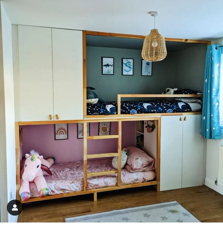 a bunk bed in a room with blue curtains and pink bedspread on the floor