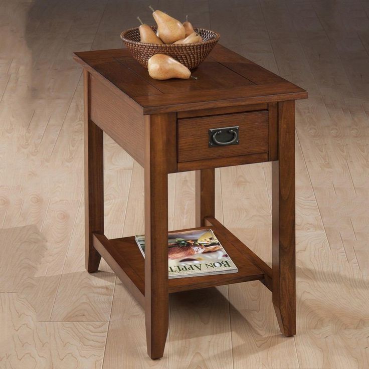 an end table with a magazine on it and some bread in a basket next to it