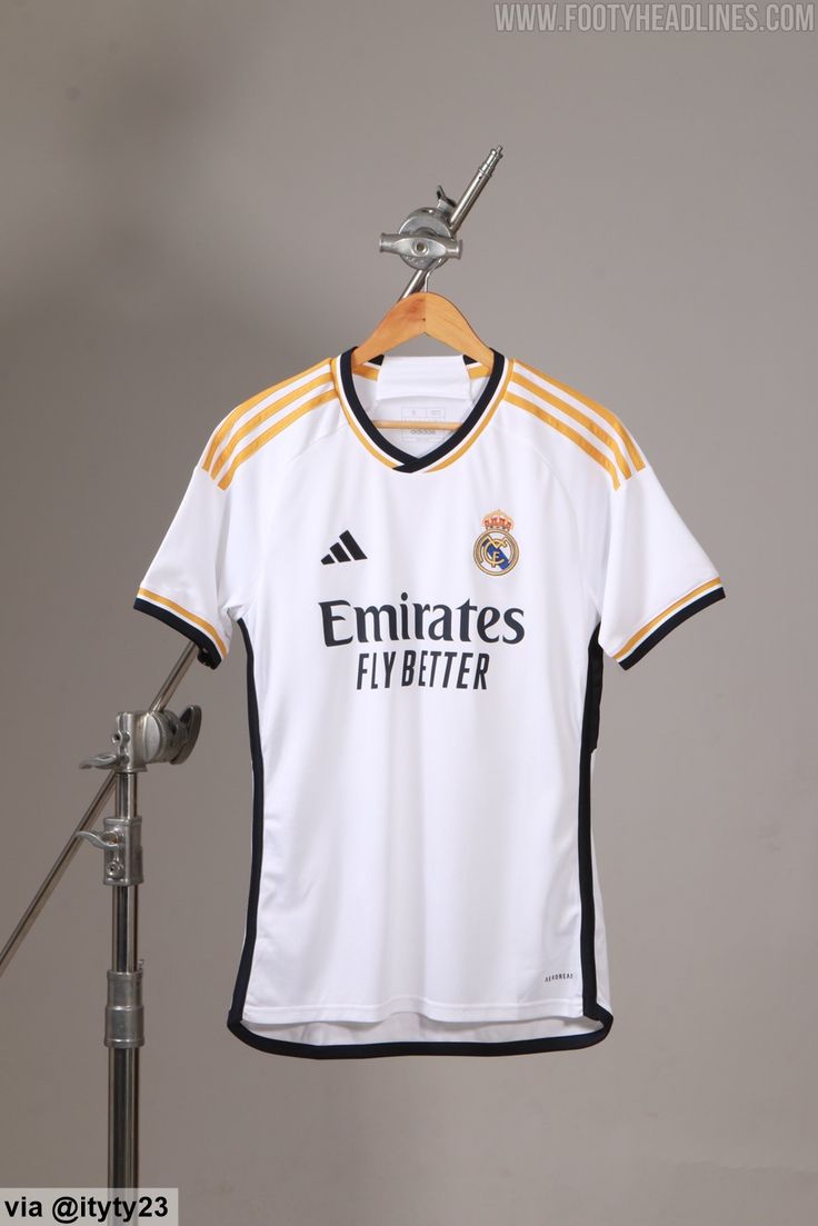 a jersey hanging on a clothes rack in front of a gray wall with a microphone next to it