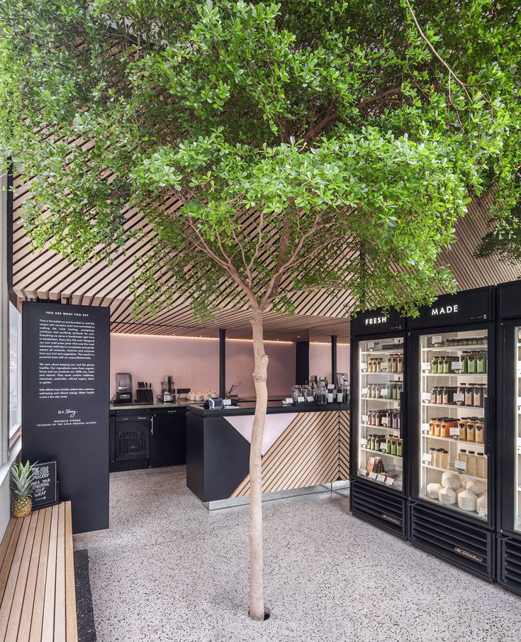 the interior of a store with an open refrigerator and trees in it's center