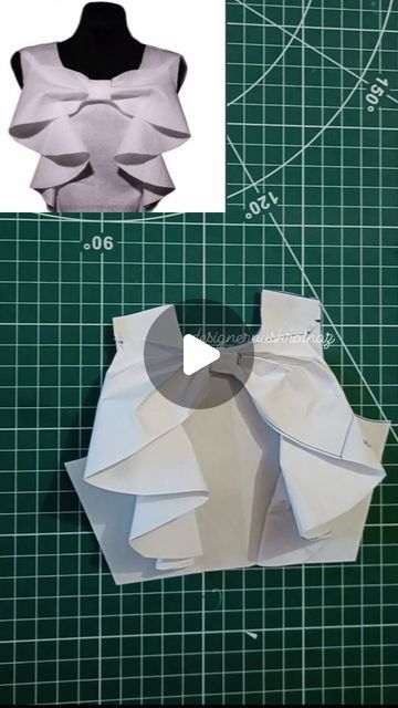 the top and bottom half of an origami shirt on a green cutting board