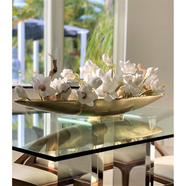 a glass table with white flowers on it