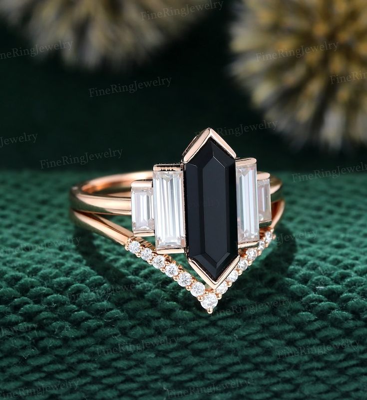 a black and white diamond ring on top of a green cloth