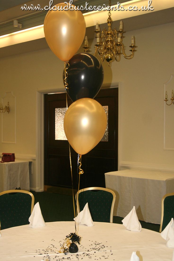 three balloons in the shape of hearts are on top of a table at a party