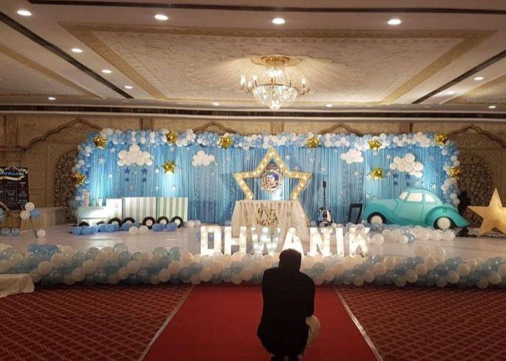 a man standing in front of a stage decorated with balloons