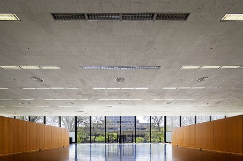 an empty room with wood paneling and large windows