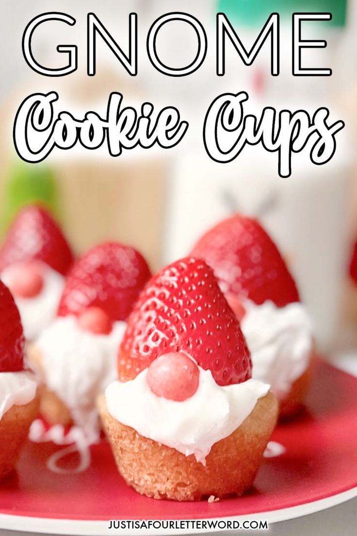 some cupcakes with strawberries and whipped cream on top are sitting on a red plate