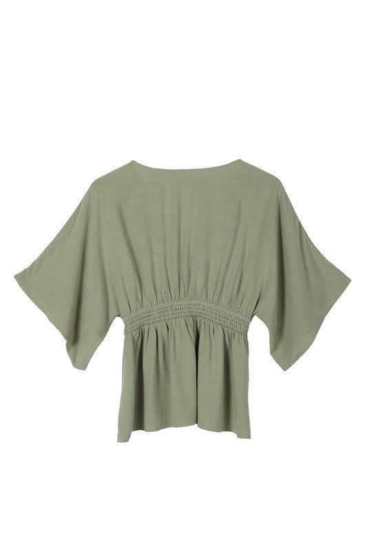 Lilou SS Deep V Neck Button Down Top Elevate your wardrobe with the Lilou SS Deep V Neck Button Down Top. This solid-colored blouse exudes elegance with its deep V neckline and kimono-style draped sleeves. Made from a comfortable cotton-linen blend in a sage color, it's perfect for any occasion. Functional buttons and a lined upper front ensure both beauty and practicality. Deep V Neckline Button Down Blouse with Draped Sleeves Pattern Type: Solid Color: Sage Neck Line: V-neck Sleeve Type: Kimon Kimono Blouse, Draped Sleeves, Athleisure Tops, Drape Sleeves, Sage Color, Kimono Sleeves, Graphic Tops, Denim Leggings, Kimono Sleeve