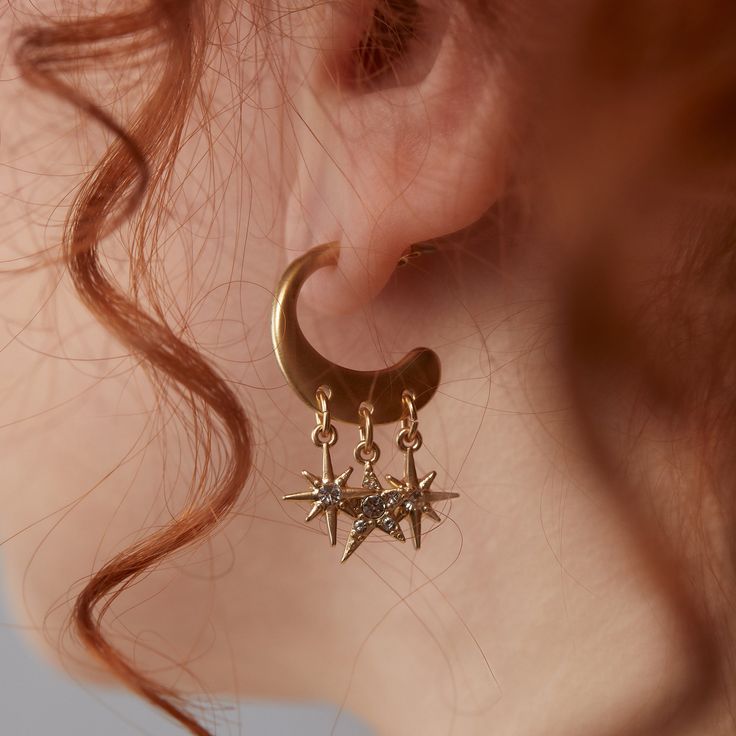 Get celestial guidance with the Star Multicharm Hoop Earrings, featuring a post-back golden hoop with dangling, crystal-detailed star charms. Celestial Earring Stack, North Star Earrings, Celestial Hoop Earrings With Star Charm, Celestial Style Dangle Earrings With Star Charm, Celestial Dangle Earrings With Star Charm, Celestial Metal Jewelry With Dangling Charms, Gold Celestial Crystal Earrings Nickel Free, Gold Celestial Crystal Earrings Nickel-free, Gold Celestial Crystal Earrings For Pierced Ears