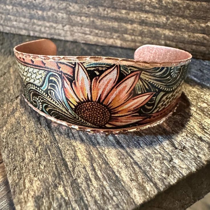 Add a touch of boho charm to your outfit with our Handmade Copper Sunflowers Cuff Bracelet. This adjustable wide cuff features intricate sunflower details and comes in a beautiful gift box. Perfect gift for any occasion. Listing for Wide Cuff only, matching earrings in another listing. Adjustable, Ships in Gift Box, FAST shipping Bohemian Stamped Bracelets As Gift, Bohemian Sunflower Design Jewelry For Summer, Bohemian Stamped Bracelets, Bohemian Stamped Cuff Bracelet For Gift, Bohemian Hand Tooled Cuff Bracelet As Gift, Bohemian Stamped Cuff Bracelet For Festivals, Bohemian Sunflower Design Summer Jewelry, Bohemian Flower Cuff Bracelet As A Gift, Bohemian Flower Cuff Bracelet As Gift