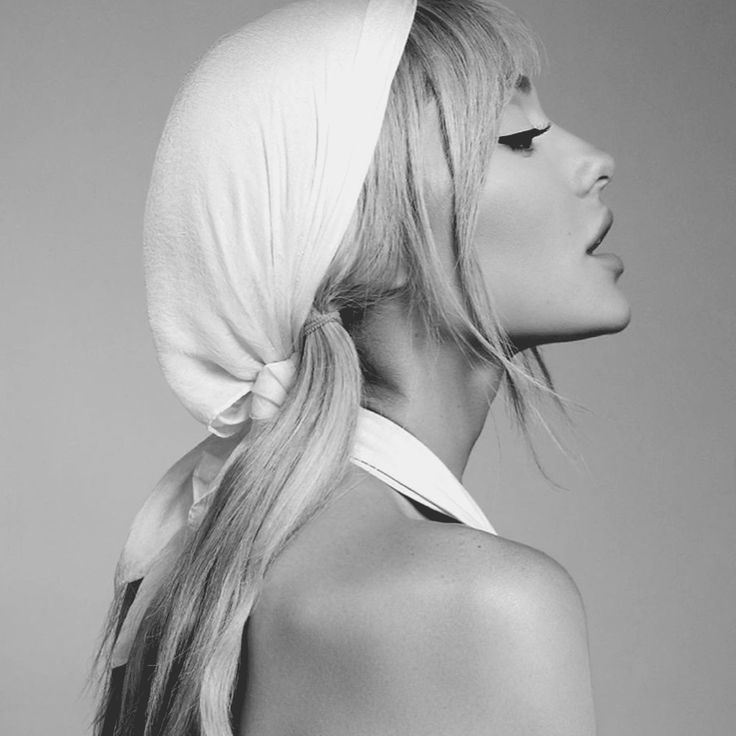 a woman with long blonde hair wearing a white head scarf on top of her head