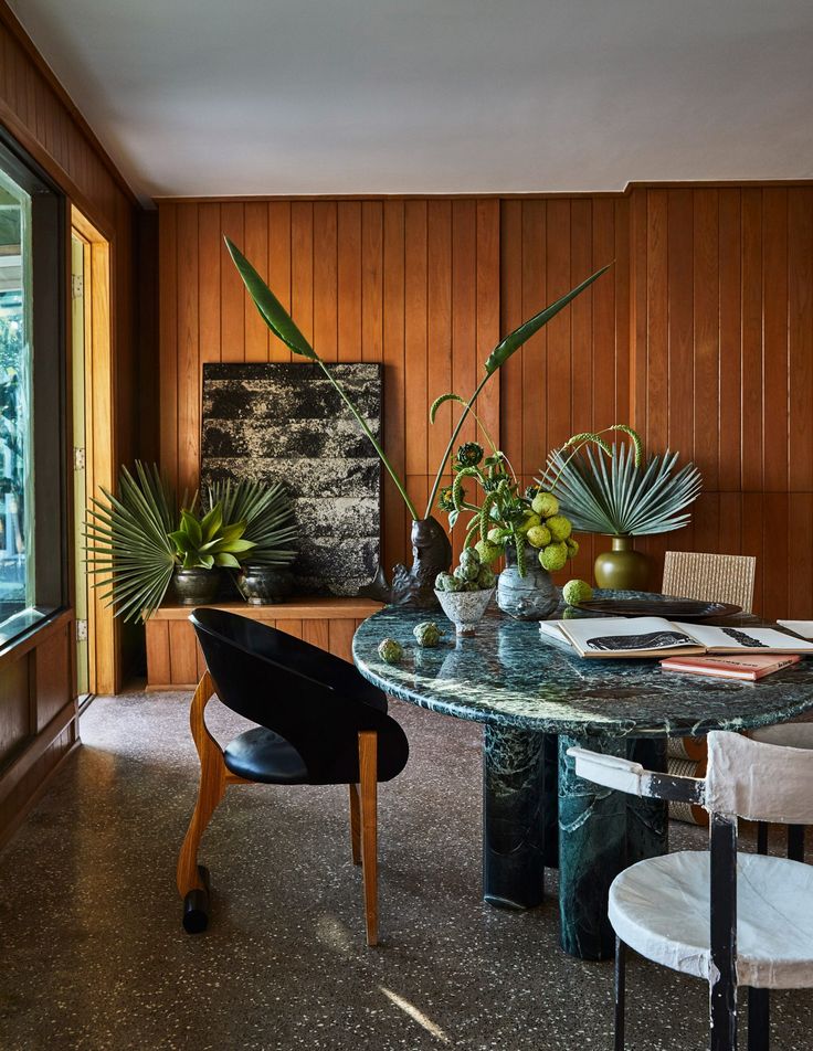 a dining room with wooden paneling and marble table