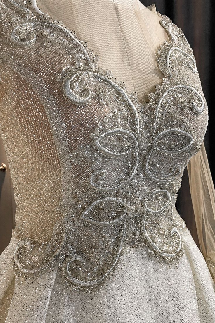 Luxurious light-reflecting true Beauty dress, covered in billions of sparkles and shiny details is what you need for your perfect wedding day. We are sure that Belle would choose this dress too, because it is absolutely princess-like and surely stunning. Fleur-de-lis motifs on the front are carefully hand-made, covering the V-lined décolleté to attract more attention. Our favorite detail of this dress is 2 different sleeves to choose from! See-through sparkly silver fabric on the sleeves adds so Different Sleeves, Corset Boning, Sparkly Wedding Dress, Tulle Top, Hair Line, Sparkly Wedding, Bra Cup Sizes, Silver Fabric, Beauty Dress