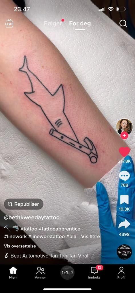 a person with a tattoo on their arm that has a shark in the middle of it