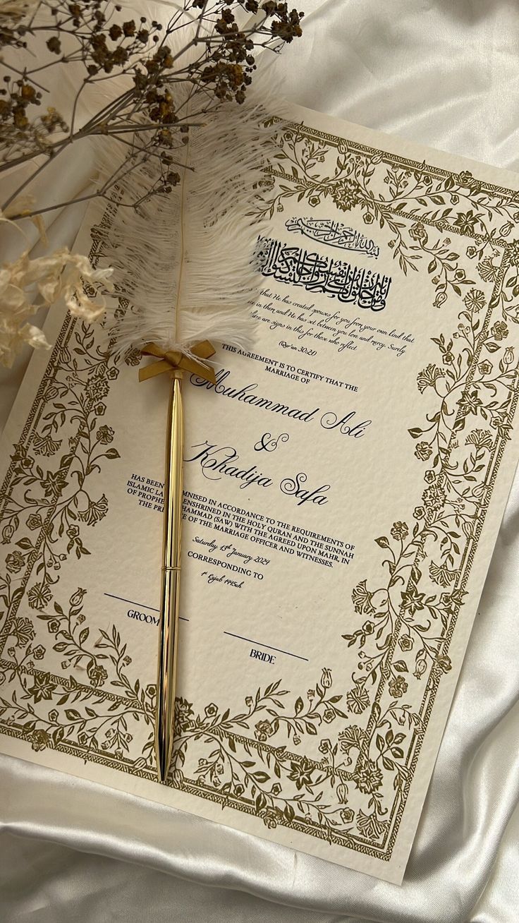 a wedding card with a feather on it and some flowers in the corner next to it