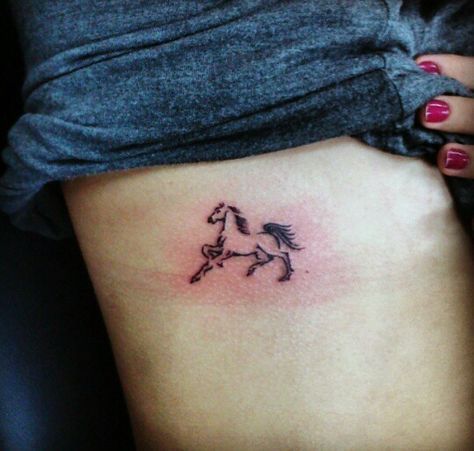 a woman's stomach with a horse tattoo on it