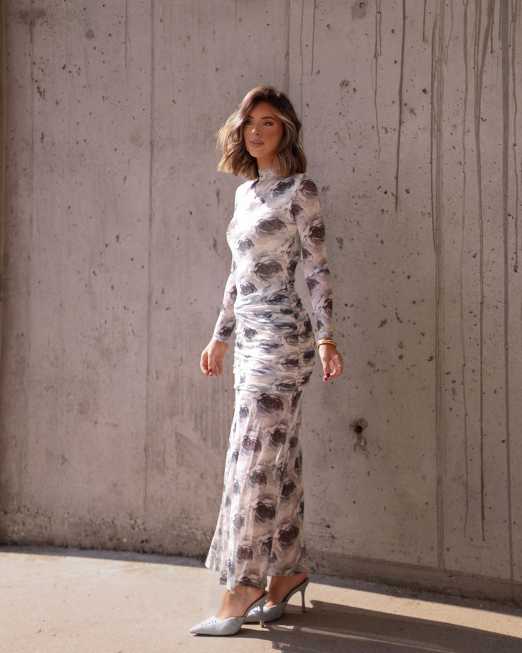 Feel elegant and flirty in our Endearing Elegance Dress. This long sleeve dress features a grey floral pattern, perfect for any fancy occasion. The flattering fit is sure to make you feel confident and beautiful. Get ready to turn heads! Fabric 95% polyester, 5% spandex Lining 100% polyester zipper in back Elegant Floral Print Maxi Dress For Date Night, Feminine Long Sleeve Midi Dress For Night Out, Feminine Long Sleeve Ruched Maxi Dress, Feminine Long Sleeve Floral Dress For Casual Wear, Feminine Long Sleeve Floral Dress For Casual Occasions, Fitted Floral Print Long Sleeve Evening Dress, Elegant Floral Maxi Dress For Casual Wear, Elegant Floral Dress For Spring Night Out, Long Sleeve Floral Dress For Casual Occasions