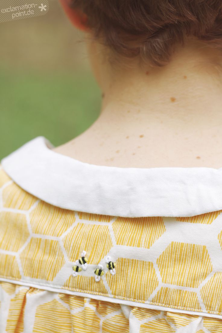 the back of a woman's yellow and white dress with honeycombs on it