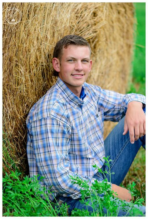 a young man sitting in front of hay bales