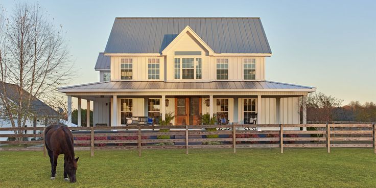 a horse grazes in front of a large house