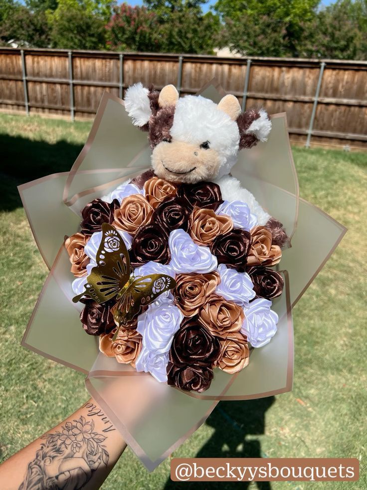 a teddy bear is holding a bouquet of flowers