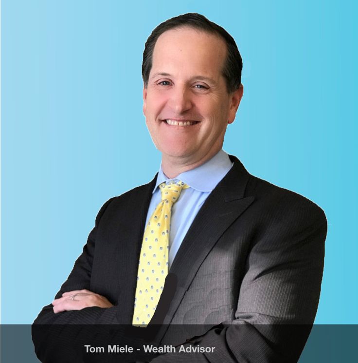 a man in a suit and tie with his arms crossed, smiling for the camera