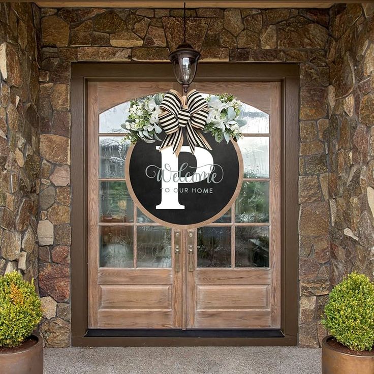 a front door with two planters and a monogrammed sign on it that says 1