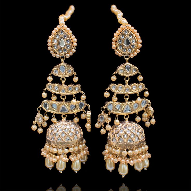 Preserve timeless charm into marvelous ensembles! With an absolute tale of elegance and sophistication, this pair showcases the beautiful composition of thapa kundan and beaded work with contemporary decorative pearl moti details adorned with true craftsmanship. Approximate earrings length is 4.5". Gold-plated on a high-quality brass as base metal. Made by order. Kindly allow 5-7 weeks for the delivery of this item. For custom or urgent requests, please contact support@alacouture.com. *Please No Elegant Chandbalis For Festivals, Elegant Designer Chandbalis For Festivals, Bollywood Style Chandbalis With Gota Work For Designer Wear, Kundan Pearl Earrings With Stone Work For Festivals, Fusion Style Kundan Bridal Earrings For Reception, Elegant Kundan Chandbalis With Meenakari, Pearl Bridal Earrings With Meenakari For Celebration, Wedding Meenakari Pearl Earrings, Elegant Chandbalis With Cutdana For Designer Wear