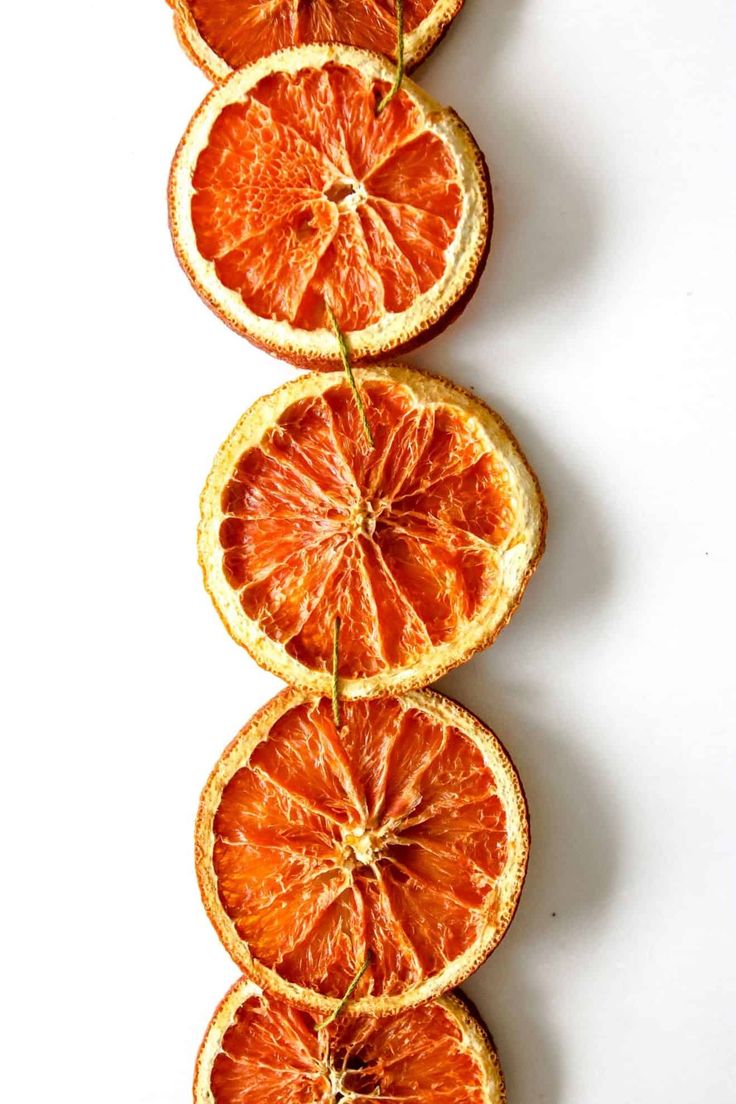 slices of oranges arranged in a row on a white surface