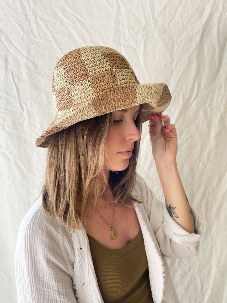 This bucket hat is casually chic and made for the beach. Beautifully crocheted in a neutral, checkerboard pattern. ﻿One size fits all. Includes adjustable strap. Brim can be folded up as pictured. Brown Woven Crochet Bucket Hat, Summer Plaid Bucket Hat, Brown Woven Bucket Hat, Summer Gingham Hat With Curved Brim, Casual Gingham Hats For Summer, Summer Plaid Brimmed Hat, Plaid Bucket Hat For The Beach, Adjustable Plaid Hats For Beach, Plaid Curved Brim Hat For Beach