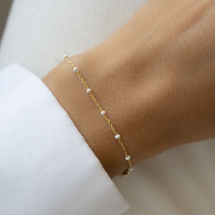 "Delicate bracelet featuring white enamel colored beads. This is an dainty and chic bracelet to add a pop of color to any outfit or look. Great for summer! Also available as anklet :) - - - D E T A I L S - - - * Made of 925 Sterling Silver * 14k Gold or Rhodium plated. We use a THICK plating for a high-quality piece that will be with you for years to come. * Available Lengths: 6.25\", 6.75\" or 7\" + 0.5\" ext * Nickel-free and Hypoallergenic * Lobster Clasp Closure * White Enamel Colored Beads Also Available in Turquoise Beads: https://www.etsy.com/listing/1516228791/turquoise-beaded-bracelet-by-sami-jewels?click_key=7b73700d9674ee3386613ee1ce0870e0b93daa54%3A1516228791&click_sum=b785a2b0&ga_search_query=turquoise&ref=shop_items_search_2&pro=1&frs=1&sts=1 Also Available as an Anklet Not s Dainty Hypoallergenic White Bracelets, Dainty White Hypoallergenic Bracelets, Dainty White Hypoallergenic Bracelet, White Minimalist Beaded Bracelets As Gift, White Minimalist Beaded Bracelets For Gift, Minimalist White Beaded Bracelets For Gift, Minimalist White Jubilee Chain Bracelet, White Minimalist Bracelet Jewelry, Minimalist White Bracelet As Gift