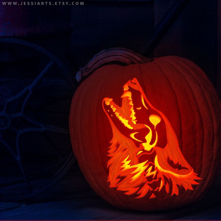 a carved pumpkin with an image of a wolf on it