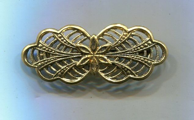 an antique gold brooch with intricate filigrees