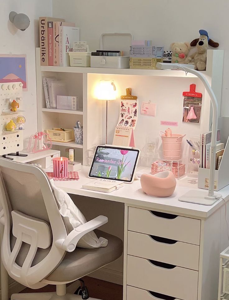 a white desk topped with a laptop computer sitting next to a drawer filled with lots of drawers