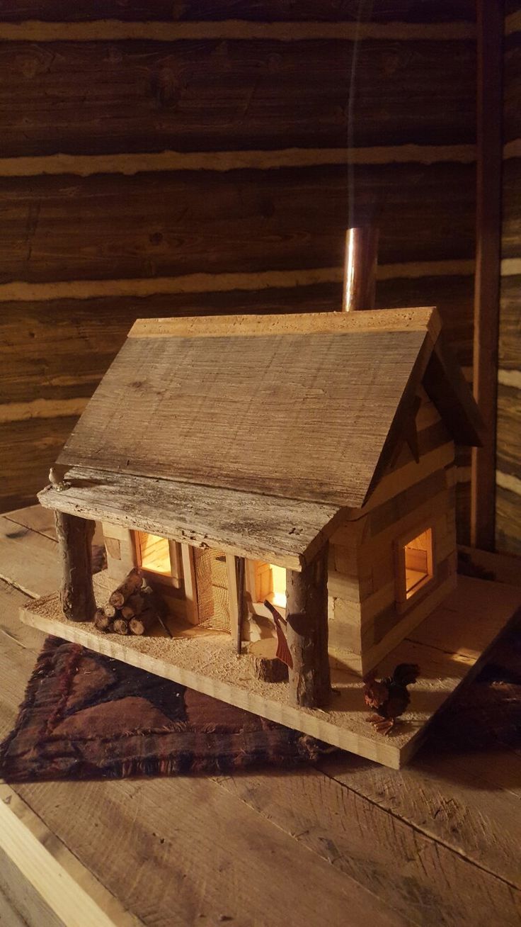 a small house made out of wood on top of a piece of wooden planks