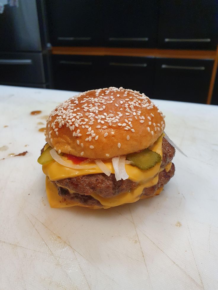 a hamburger with cheese and pickles on it