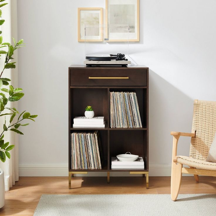 a record player sitting on top of a shelf next to a chair