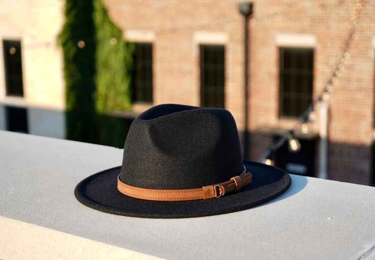 A new spin on our best-selling hat, the Clarke fedora embodies a balance between modern and vintage with its simplistic design, which is offset by a hand-stitched leather headband. Available in size Medium 54-58cm and Large 59-62cm. Features an adjustable inner strap to ensure your hat is the proper fit. Removable headband Specifications:Crown Height: 5"Brim Width for Medium: 2.65"Brim Width for Large: 2.9"Material: Polyester All hats ship from Dallas, Texas. Leather Headband, Womens Fedora, Black Fedora, Fedora Hat Women, Leather Headbands, Wide Brim Fedora, Fall Hats, Stylish Hats, Simplistic Design