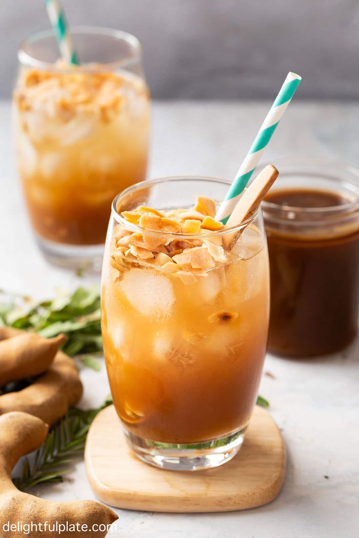 two glasses filled with iced coffee on top of a table