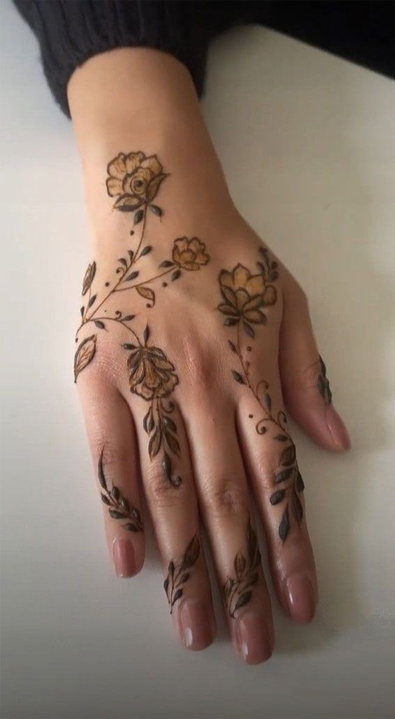 a woman's hand with hennap on it and flowers painted on the palm