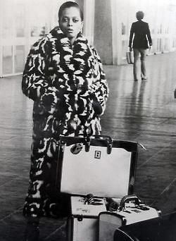 a black and white photo of a person with luggage