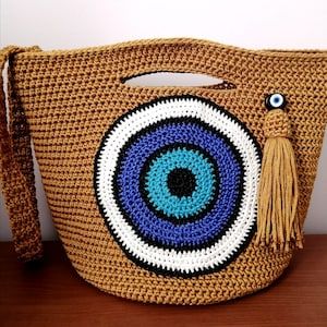 a crocheted bag with an evil eye on it