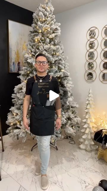 a man standing in front of a christmas tree